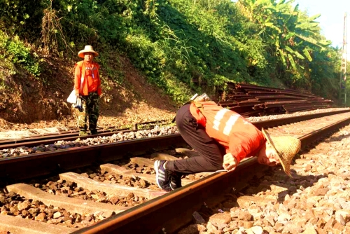 圖為：巡線員劉鈺跪在鋼軌上查看線路水平、高低，及時發(fā)現(xiàn)病害位置，確保列車運行安全。　粘孝康　攝