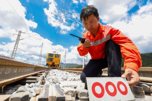 圖為鐵路工人正在高溫環(huán)境下擺放作業(yè)標(biāo)志牌，確保作業(yè)安全。