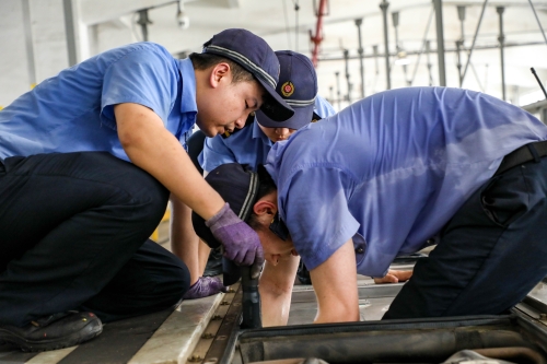 動(dòng)車組機(jī)械師正在更換動(dòng)車組空調(diào)送風(fēng)機(jī)。（李長安 攝）